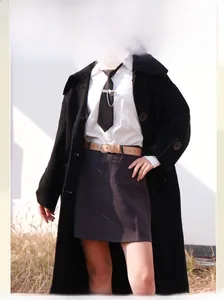 Dettaglio di una cintura in pelle marrone con fibbia argento su gonna e camicia