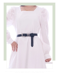 Détail d'une ceinture en cuir noir avec boucle argentée et boucles à trois anneaux métal
