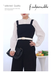 Detail view of a white PU leather belt with a golden oval buckle on a black dress
