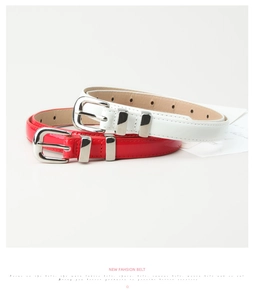 Détail de ceintures fines en cuir verni rouge et blanc avec boucles argentées brillantes