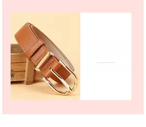 Detail of caramel leather belt featuring a gold bamboo-textured horseshoe buckle