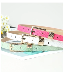 Close-up of three women's thin belts in pink, white, and green with gold wavy buckles