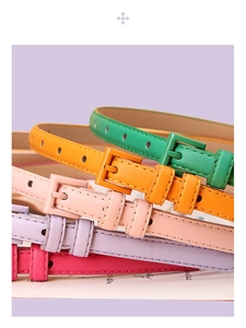Dettaglio di cinture sottili in pelle color caramella con fibbie quadrate abbinate