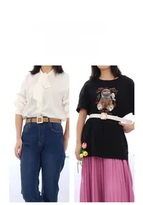Detail of tan and white skinny belts with square gold buckles on denim jeans