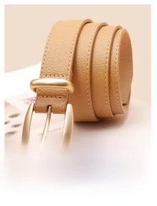 Détail de ceinture en cuir marron clair avec boucle dorée mate et surpiqûres blanches élégantes