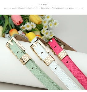 Detail of snake skin texture leather belts in mint, white and pink with gold metal buckles