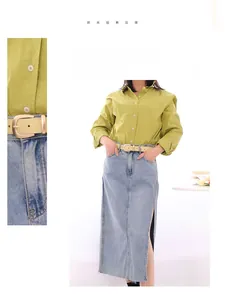 Vue détaillée d'une ceinture en cuir beige avec boucle dorée sur jupe en jean et chemise