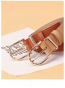 Close-up of litchi grain leather belts featuring vintage golden bamboo buckle detail