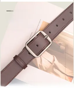 Detail of dark brown leather belt with lychee texture and silver matte buckle