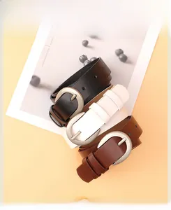 Dettaglio di tre cinture in pelle nei colori nero bianco e marrone con fibbie a ferro di cavallo