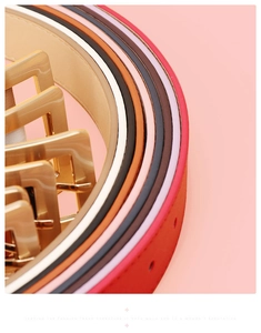 Close-up of colorful women's leather belts with polished gold square buckles on pink background