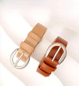 Cinture minimaliste in pelle kaki e marrone scuro con fibbie argentate su base espositiva