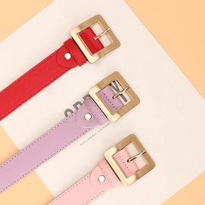Three minimalist women's leather belts in red, pink, and purple with gold square buckles