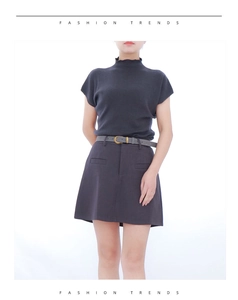 Close-up of a charcoal grey mock neck knit sweater and high waist A-line skirt with belt