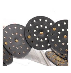 Gros plan d'une ceinture large rétro noire avec cercles ajourés et rivets en bronze
