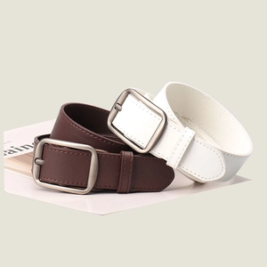 Detailed view of dark brown and white faux leather belts with matte grey pin buckles