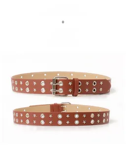 Dettaglio cintura punk in pelle marrone con doppi occhielli e borchie a stella