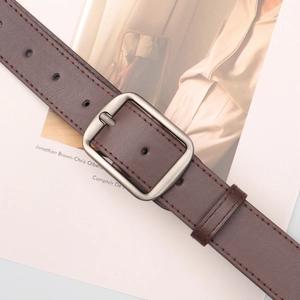 Minimalist brown leather belt with matte silver buckle and red stitching details