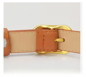 Close-up of brown leather belt with premium gold alloy buckle and fine stitching