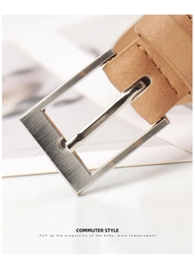 Macro detail of camel leather belt featuring a brushed silver rectangular needle buckle