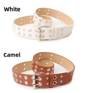 Dettaglio cinture punk bianche e color cammello con borchie a stella e occhielli