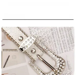 Vue détaillée d'une ceinture Y2K en cuir blanc avec strass brillants et boucle en métal
