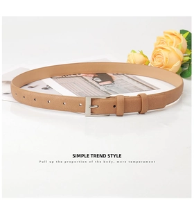Detail of light khaki leather belt with lychee texture and silver pin buckle closure