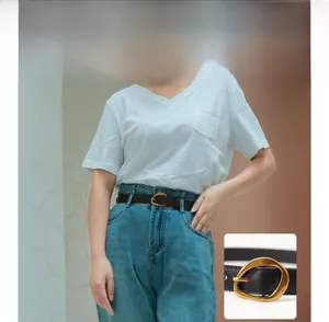 Détail d'une ceinture marron rétro avec boucle dorée sur un jean taille haute