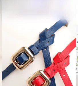 Detail of trendy slim waist belts in blue and red leather with golden buckles