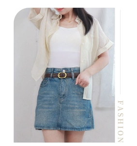 Detail of high-waist denim skirt styled with a vintage dark brown leather belt