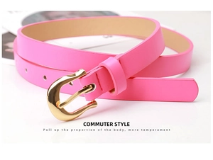 Détail d'une ceinture rose en similicuir avec boucle fer à cheval dorée sur fond blanc