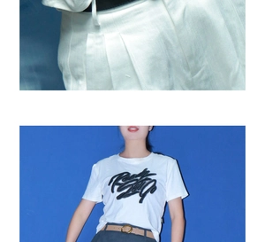 Détail d'un pantalon plissé blanc avec texture sergée et tombé fluide sur fond bleu