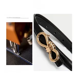 Detail of sewing craft on black leather belt with golden infinity knot buckle