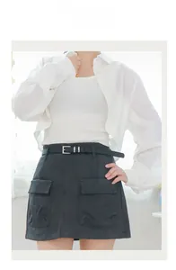 Detail of high-waist black cargo mini skirt with two utility pockets and matching belt