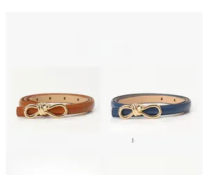 Detail of camel and navy blue skinny belts featuring golden bow metal buckles for women