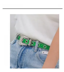 Gros plan d'une ceinture Y2K verte étincelante avec boucle de luxe sur un jean