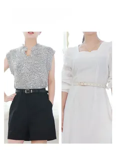 Styling detail of slim black and beige belts with gold buckles on shorts and dresses