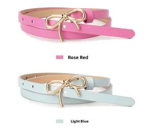 Dettaglio di sottili cinture in pelle rosa e azzurro con fibbie a fiocco d'oro