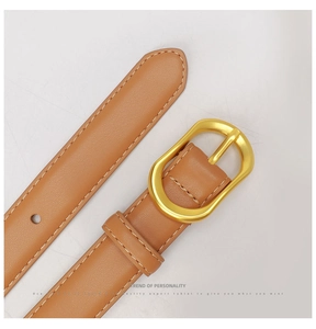 Detail of a brown leather belt with a golden oval buckle and fine stitching