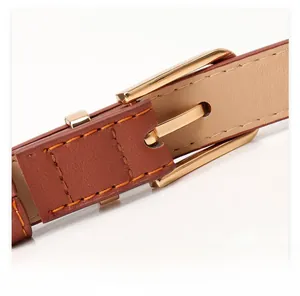 Close-up of brown leather belt featuring a polished gold buckle and fine stitching detail
