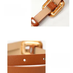 Detail of a thin brown PU leather belt with polished gold pin buckle and neat perforations