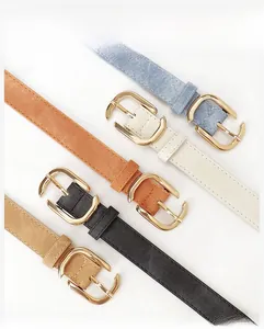 Détail de cinq ceintures en similicuir denim de couleurs variées avec boucles dorées en D