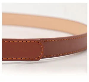 Close-up of brown faux leather belt featuring orange contrast stitching and fine texture