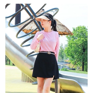 Close-up of a slim grey belt with metal buckle on a black A-line mini skirt