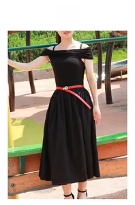 Detail of red thin leather belt knot tied on a black off-shoulder pleated dress