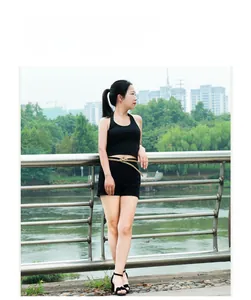Detailed view of women's khaki skinny belt with a gold bow buckle on outdoor model