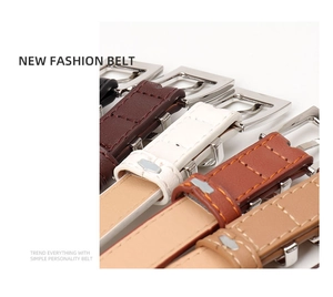 Detail of square silver buckles and faux leather belts in brown, white, and tan