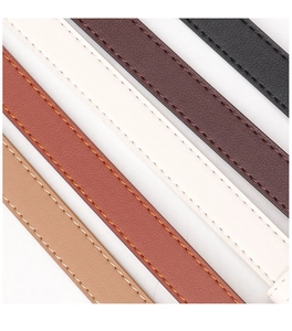 Close-up of leather belt straps in various colors showing fine litchi texture and stitching