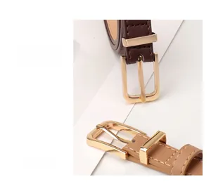 Detail of dark coffee and light camel slim leather belts with golden square buckles