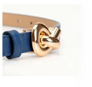 Close-up of a women's navy blue leather belt with a golden alloy knot buckle detail